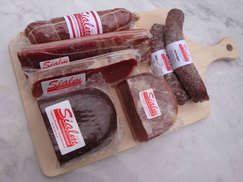 Geschenkbrett mit Salami, drei Rohwürsten, Scheibe Beinschinken, Scheibe Bauernschinken, Bündnerflesich und Rohnussschinken