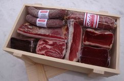 Geschenkkiste mit Bündnerfleisch, Rohnusschinken, Coppa, Hirschtrockenfleisch, Scheibe Beinschinken, Rohspeck, Salami und drei Rohwürste.